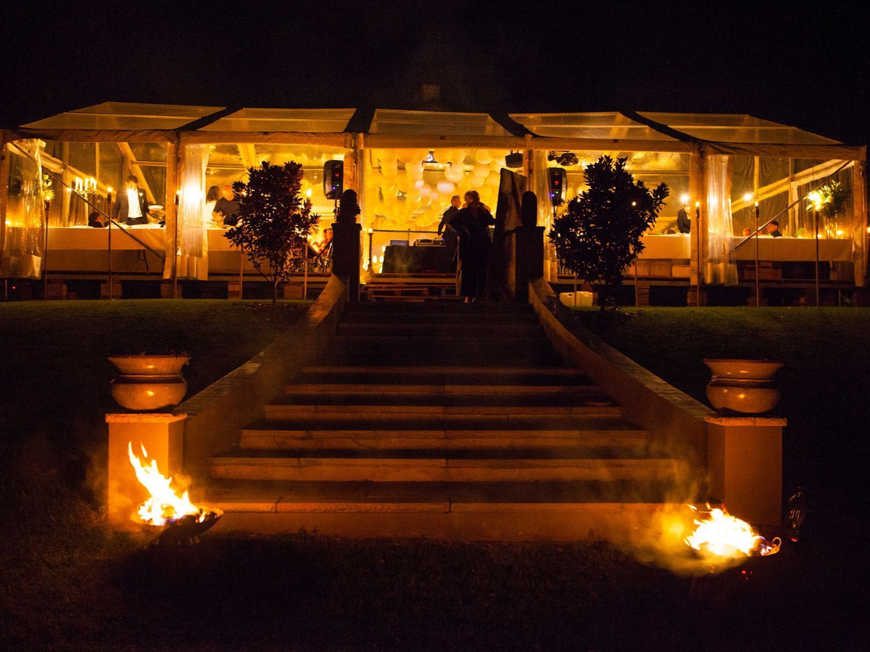 Stairs leading up to a clear tent at night