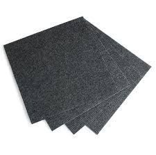 Four pieces of black carpet are stacked on top of each other on a white background.