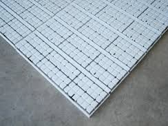 A close up of a white tile floor on a concrete floor.