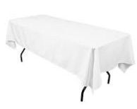 A white table cloth is sitting on top of a white folding table.