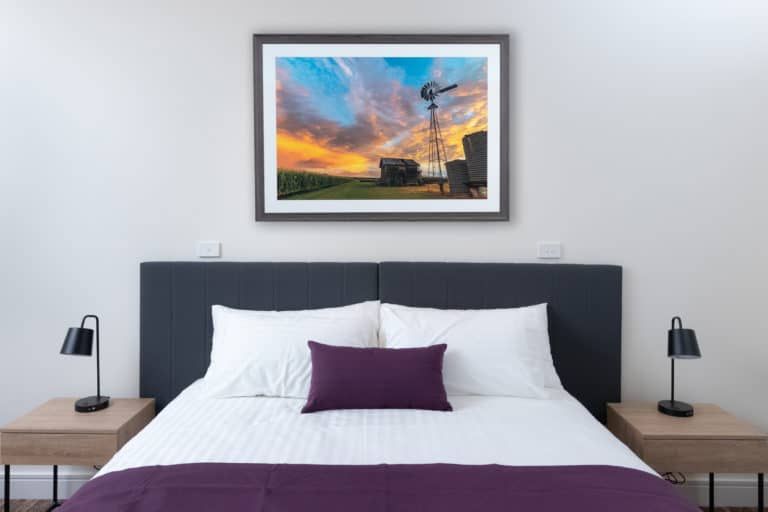 A Bedroom With a Bed and a Picture on the Wall Above It — Gold Coast Printing & Framing in Burleigh Heads, QLD