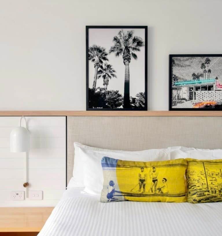 A Bed With a Yellow Pillow and Two Pictures on the Wall Above It — Gold Coast Printing & Framing in Burleigh Heads, QLD