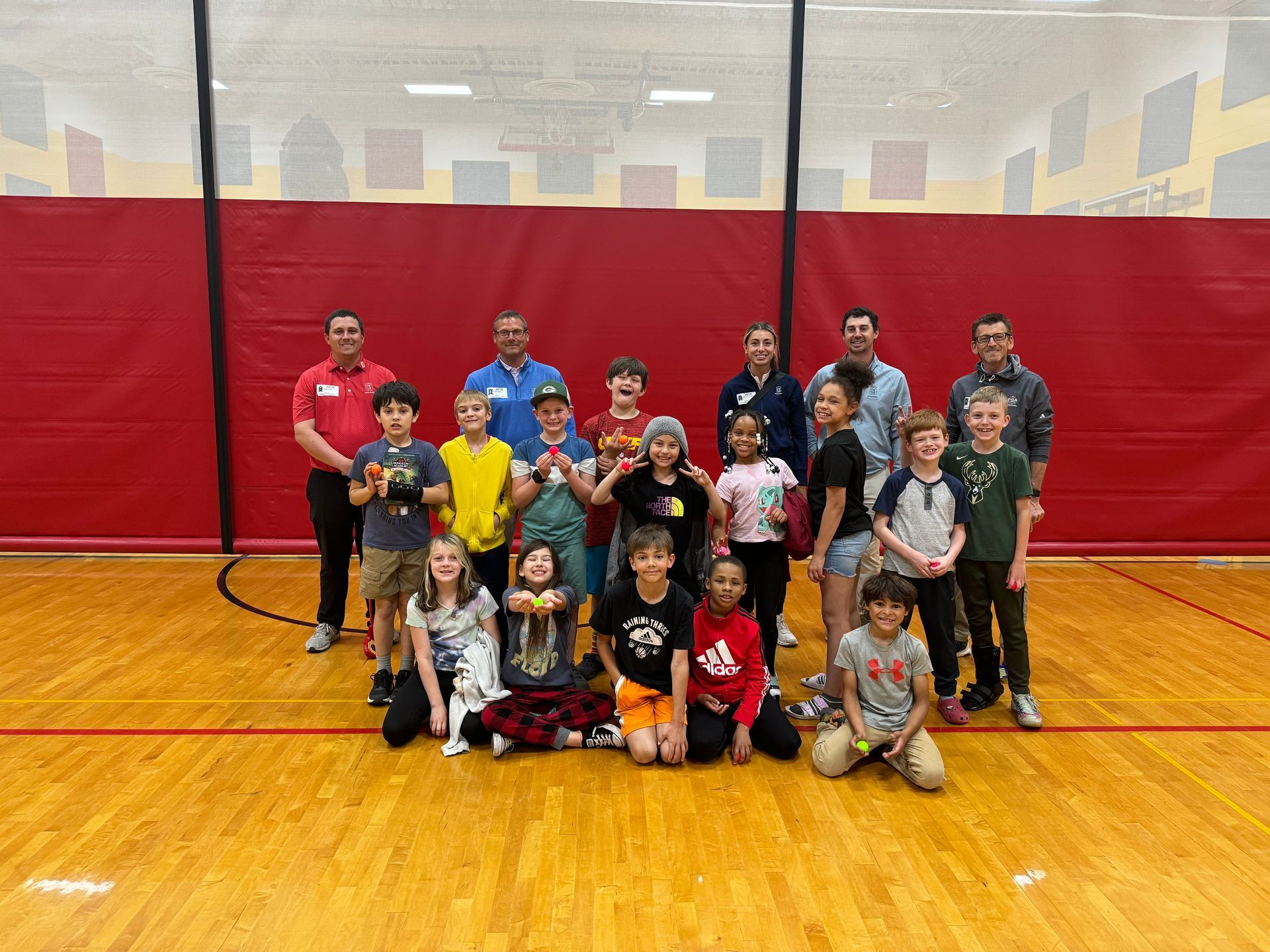 A group of children are posing for a picture in a gym.