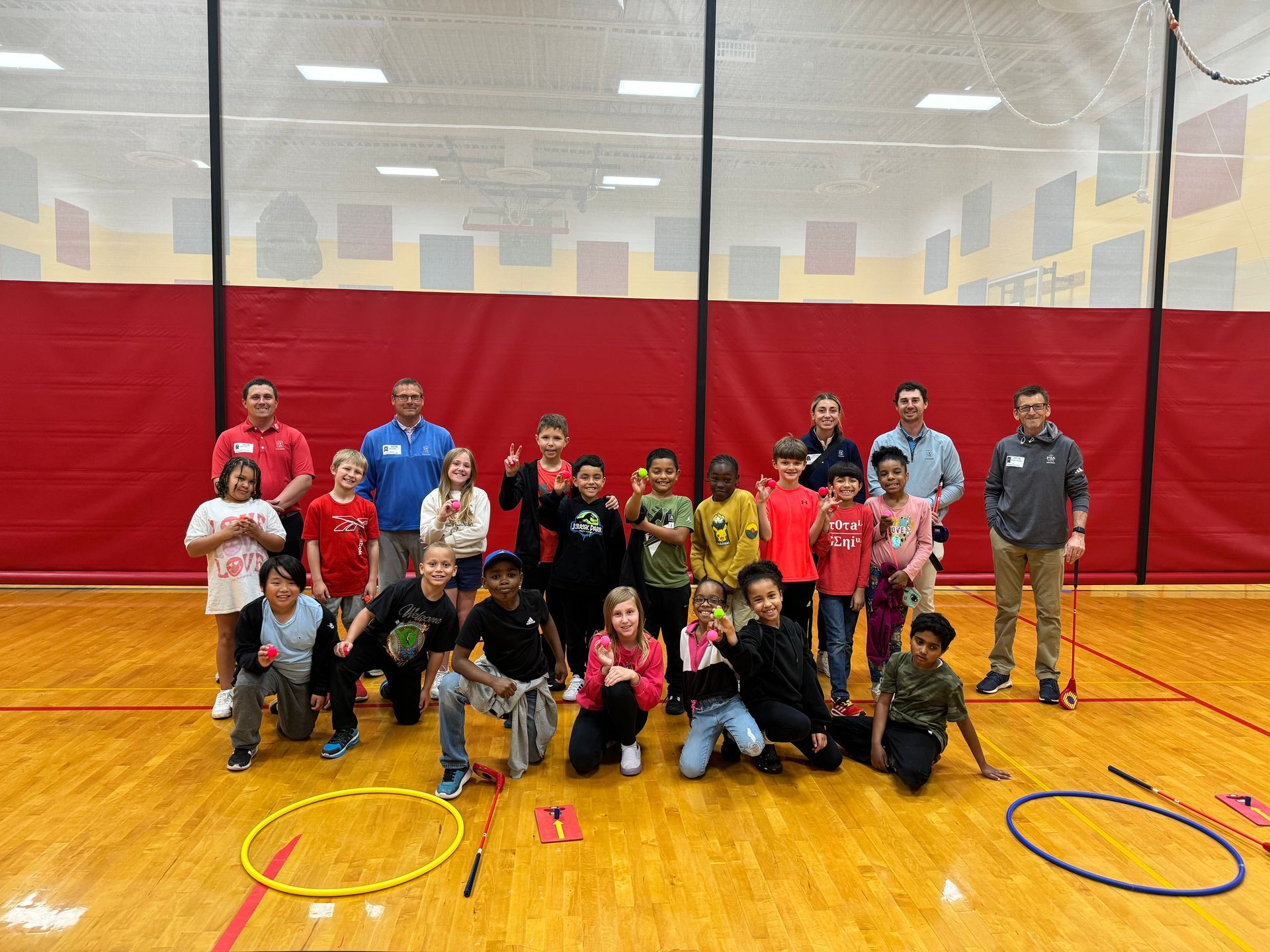 A group of children are posing for a picture in a gym.