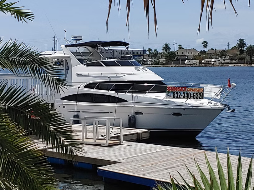 A large white boat is docked at a dock with a sign on the side that says " for sale "