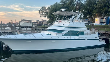 A large white boat is docked in the water near a dock.