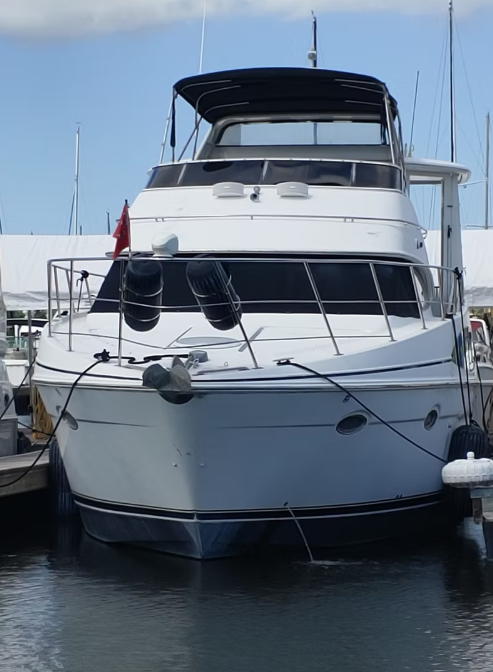 A large white boat is docked at a marina