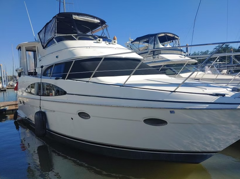 A large white yacht is docked in a marina.