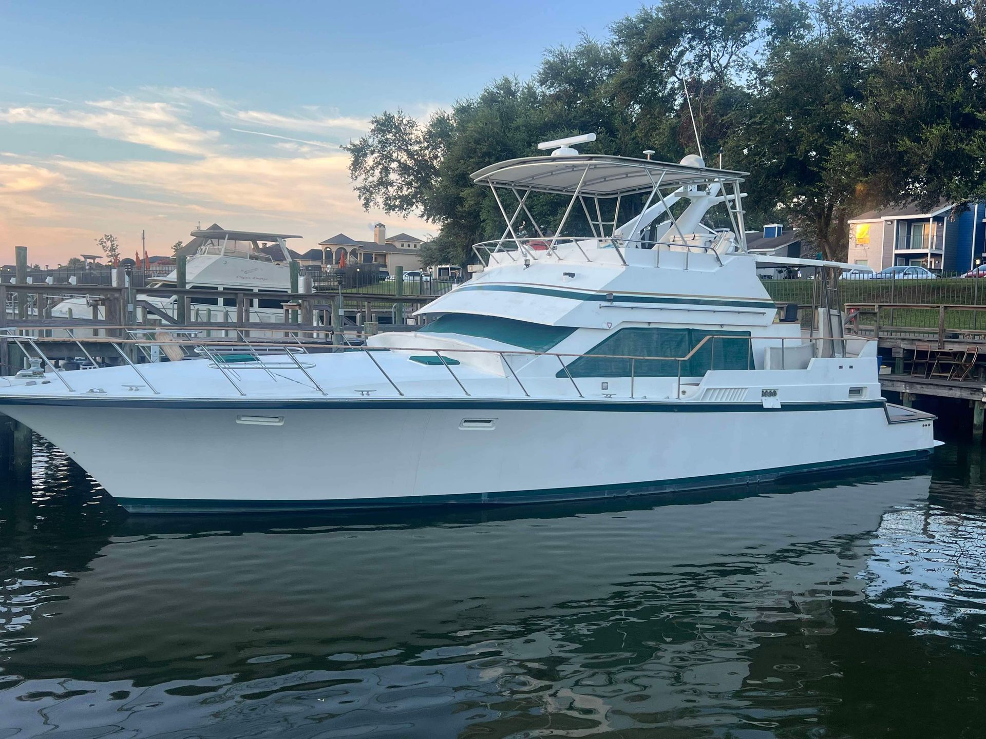 A large white boat is docked at a dock in the water.