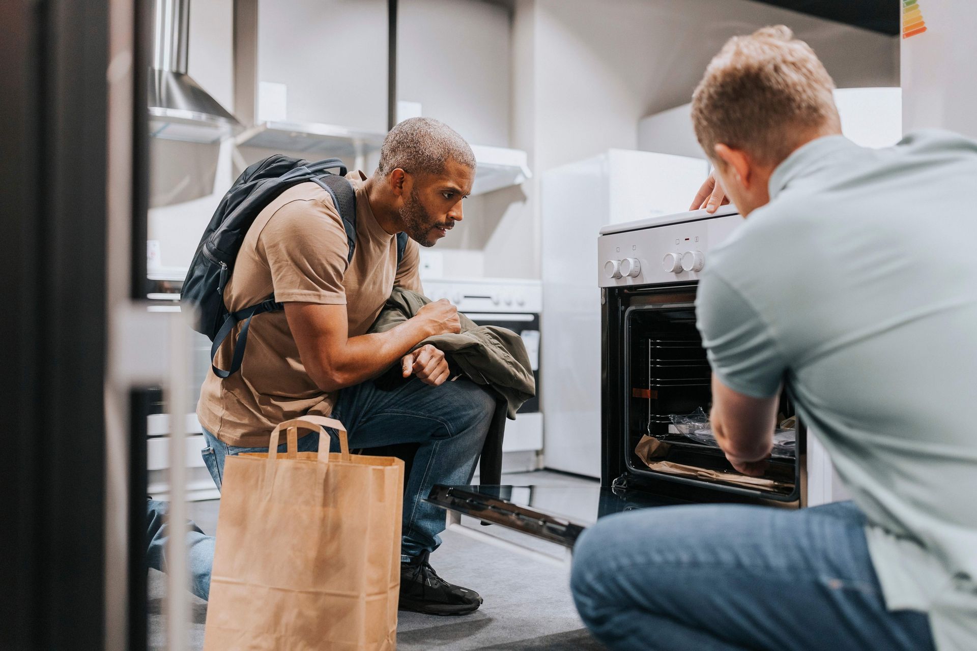 Salesman advising male customer in buying modern appliance at electronics store. Salesman advising male customer in buying modern appliance at electronics store.