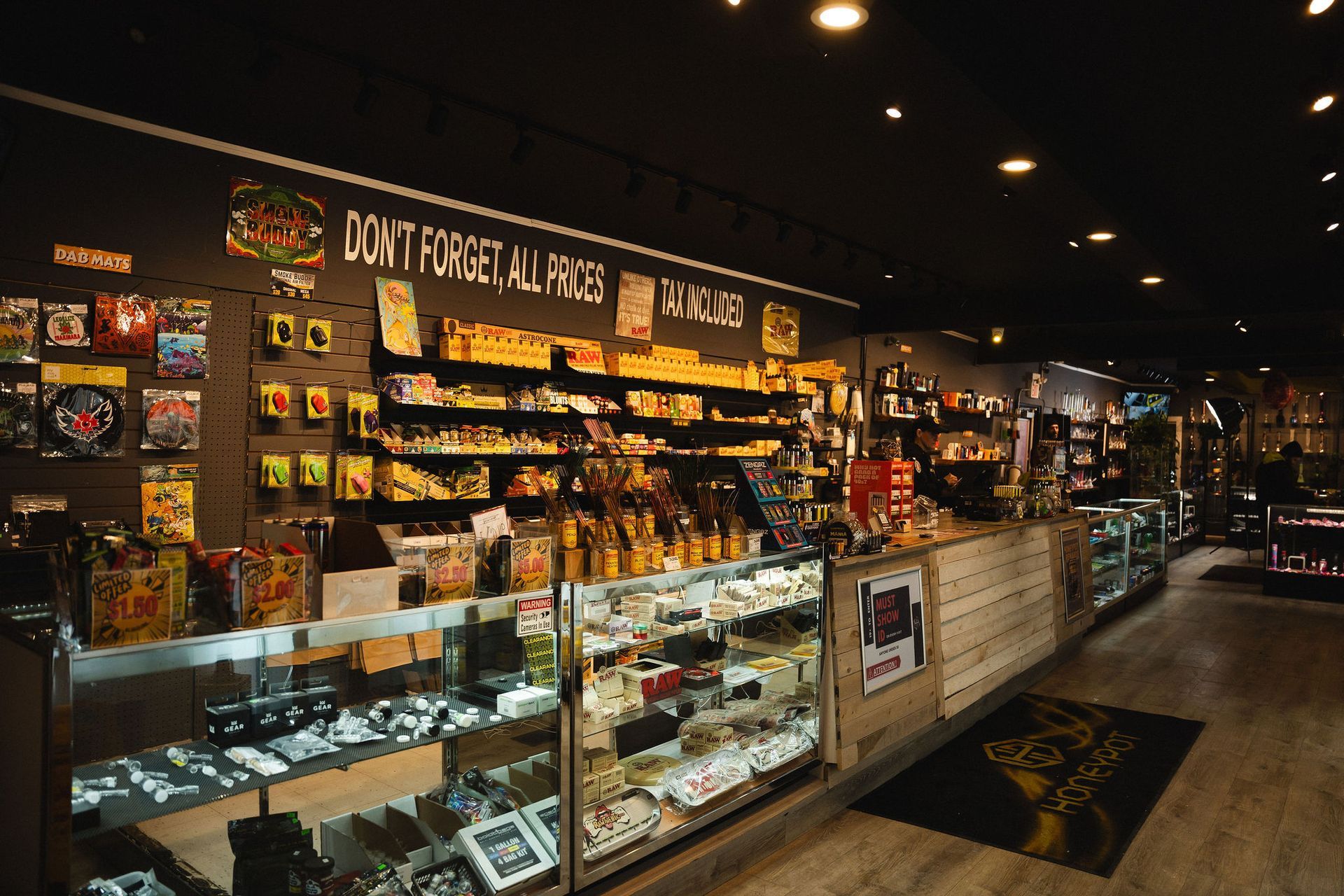 A brightly lit, modern retail store featuring glass display cases filled with products and shelves lining the dark wall.