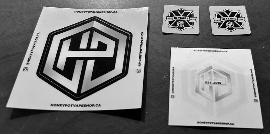 Several black and white brand stickers featuring hexagon logos and the text 