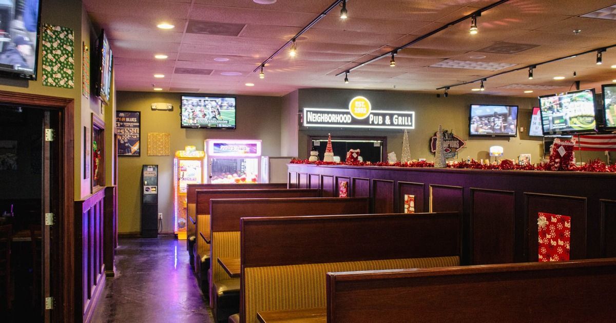 A restaurant with a lot of tables and televisions on the wall.