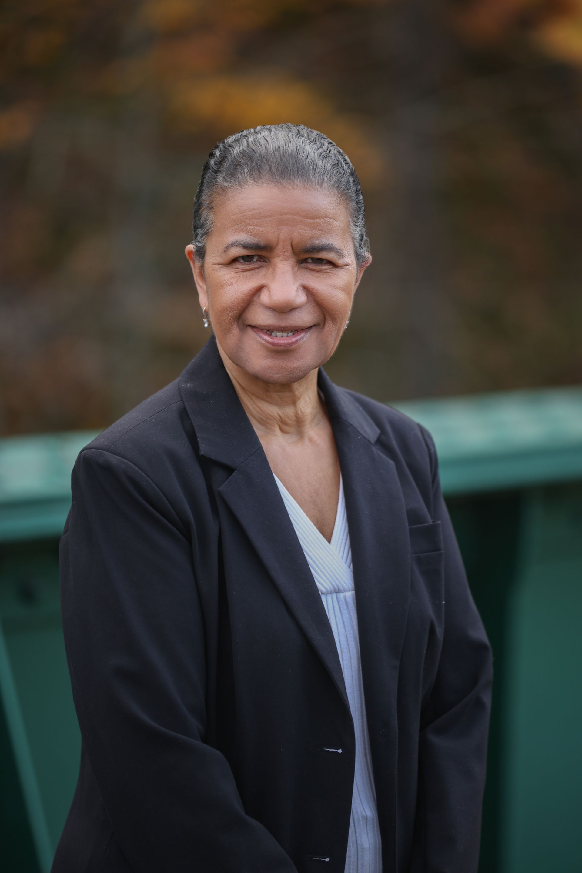 Caricature of woman in a black suit, arms crossed, smiling; likely a professional portrait.