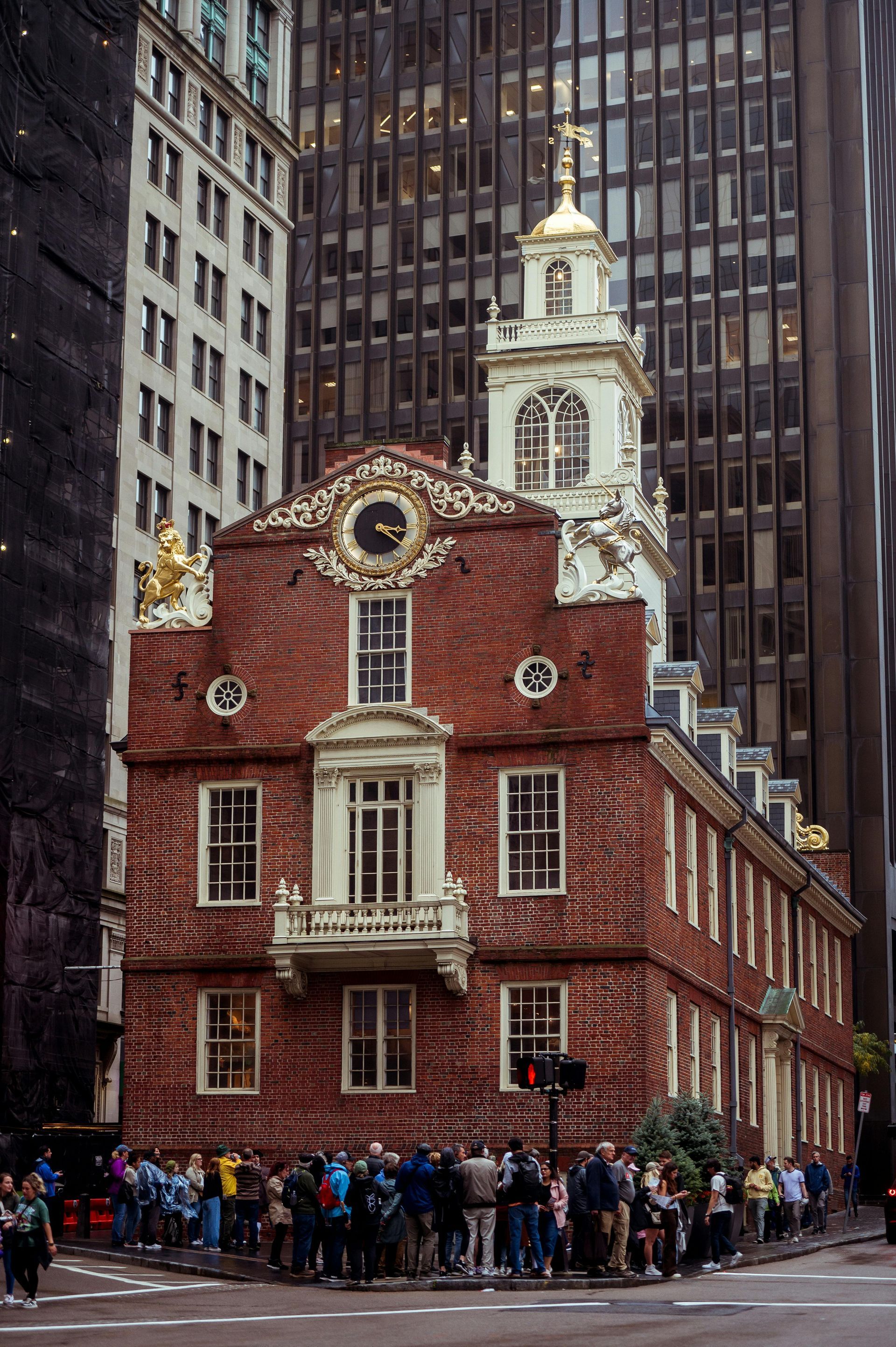 Old State House, Boston, brick building with clock tower, surrounded by modern skyscrapers and a crowd of people.