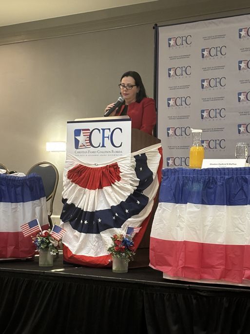 A woman is giving a speech at a podium that says CFC