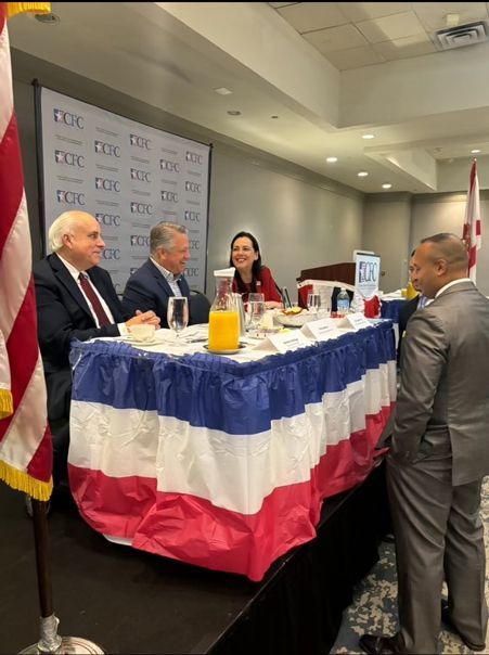 A group of people sitting at a table with a red white and blue table cloth