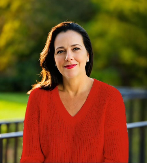 A woman in a red sweater is smiling for the camera