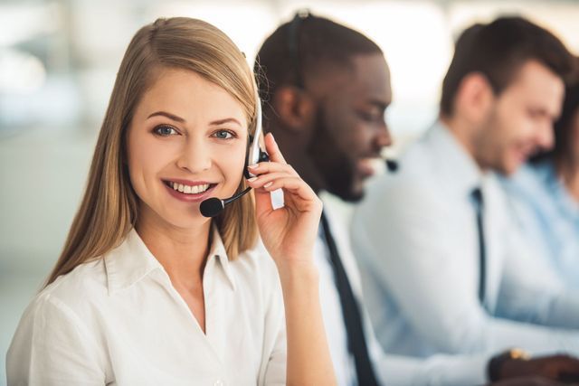 A woman is wearing a headset in a call center
