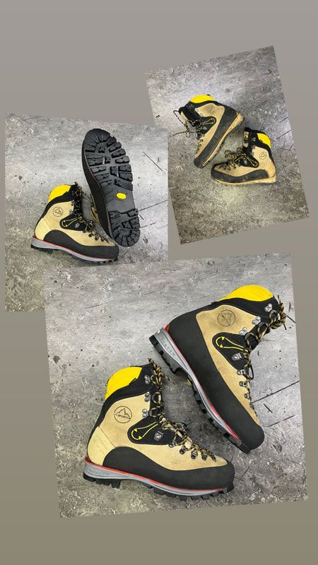 Verschillende bruine en zwarte wandelschoenen met gele accenten op een grijze achtergrond.