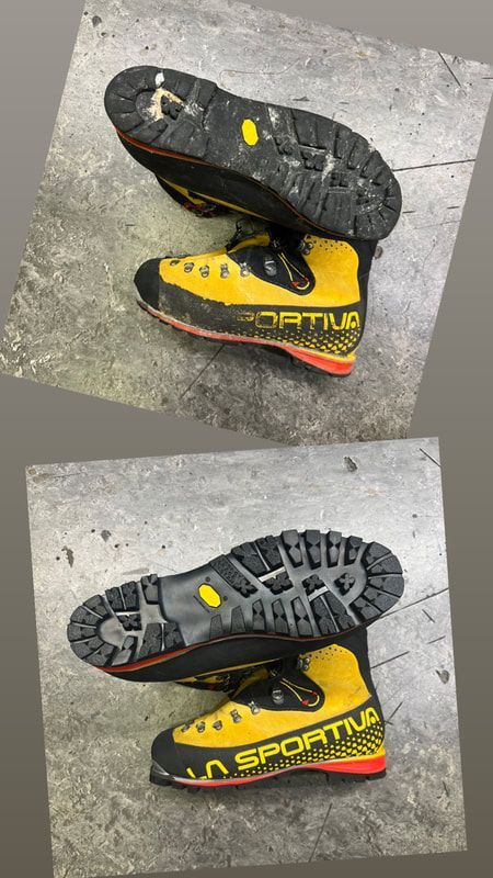 Een paar geel-zwarte klimschoenen van La Sportiva op een grijze ondergrond, waarbij de zolen en zijkanten zichtbaar zijn.