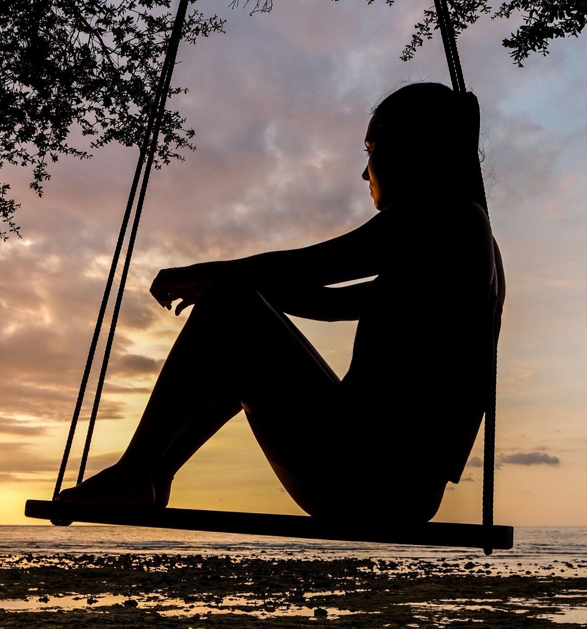 sad-person-silhouette-dealing-with-loss-sitting-on-swing-during-sunset