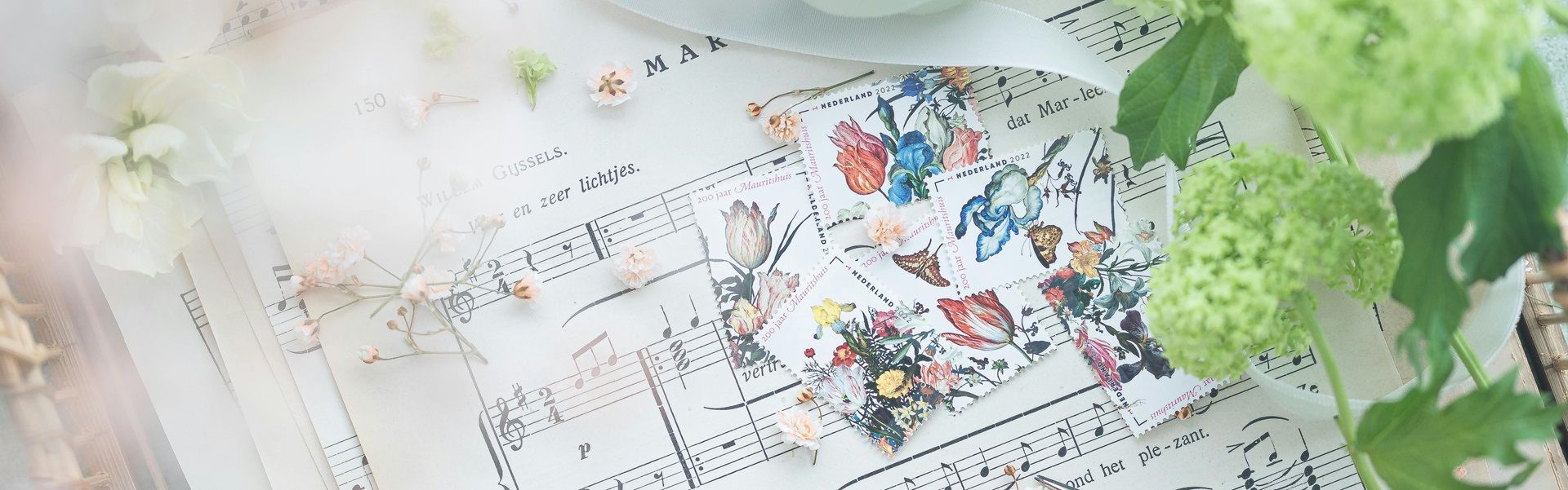 music-notes-and lyrics-on-paper-with-some-tiny-flowers-and-flower-stamps-on-top
