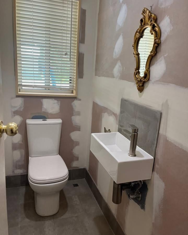 A Bathroom with A Toilet a Sink and A Mirror — Bowral Bathrooms in Exeter, NSW