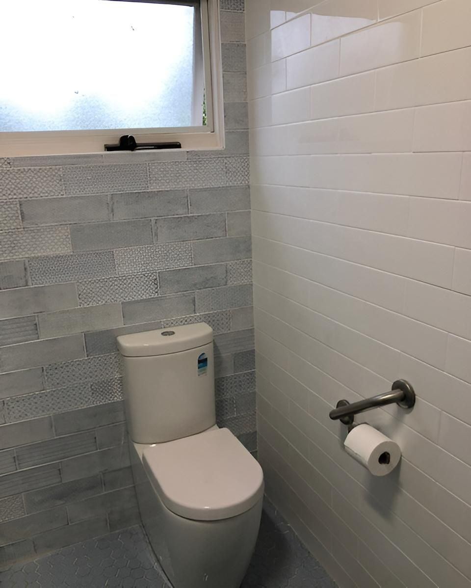A Toilet Is Sitting in A Bathroom Next to A Window — Bowral Bathrooms in Exeter, NSW