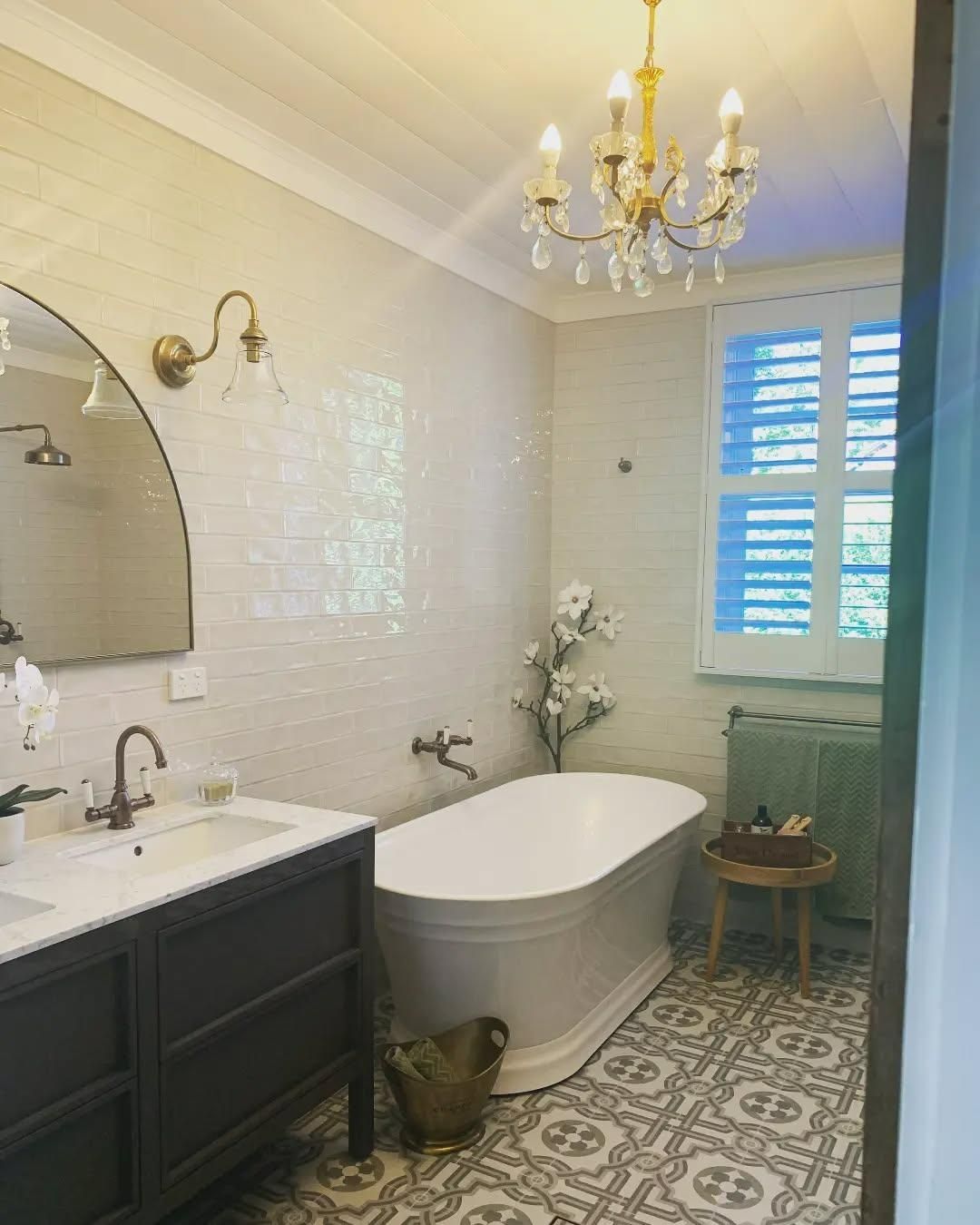 A Bathroom with A Bathtub, Sink, Mirror and Chandelier — Bowral Bathrooms in Exeter, NSW