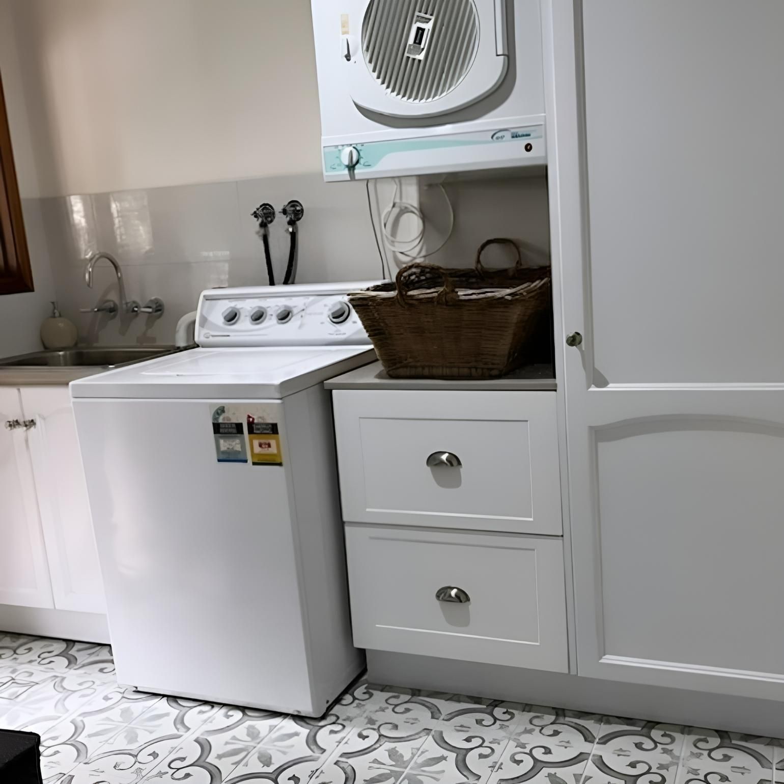 A Laundry Room with A Washer and Dryer and A Basket on The Counter — Bowral Bathrooms in Exeter, NSW
