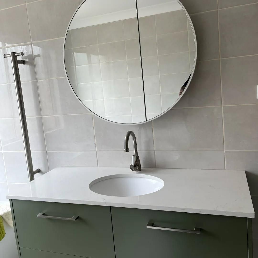 A Bathroom Sink with A Round Mirror Above It — Bowral Bathrooms in Exeter, NSW