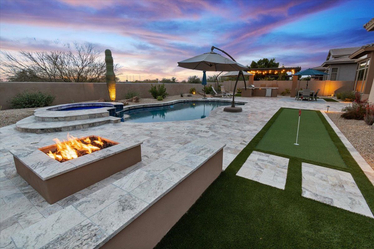 A backyard with a fire pit and a putting green