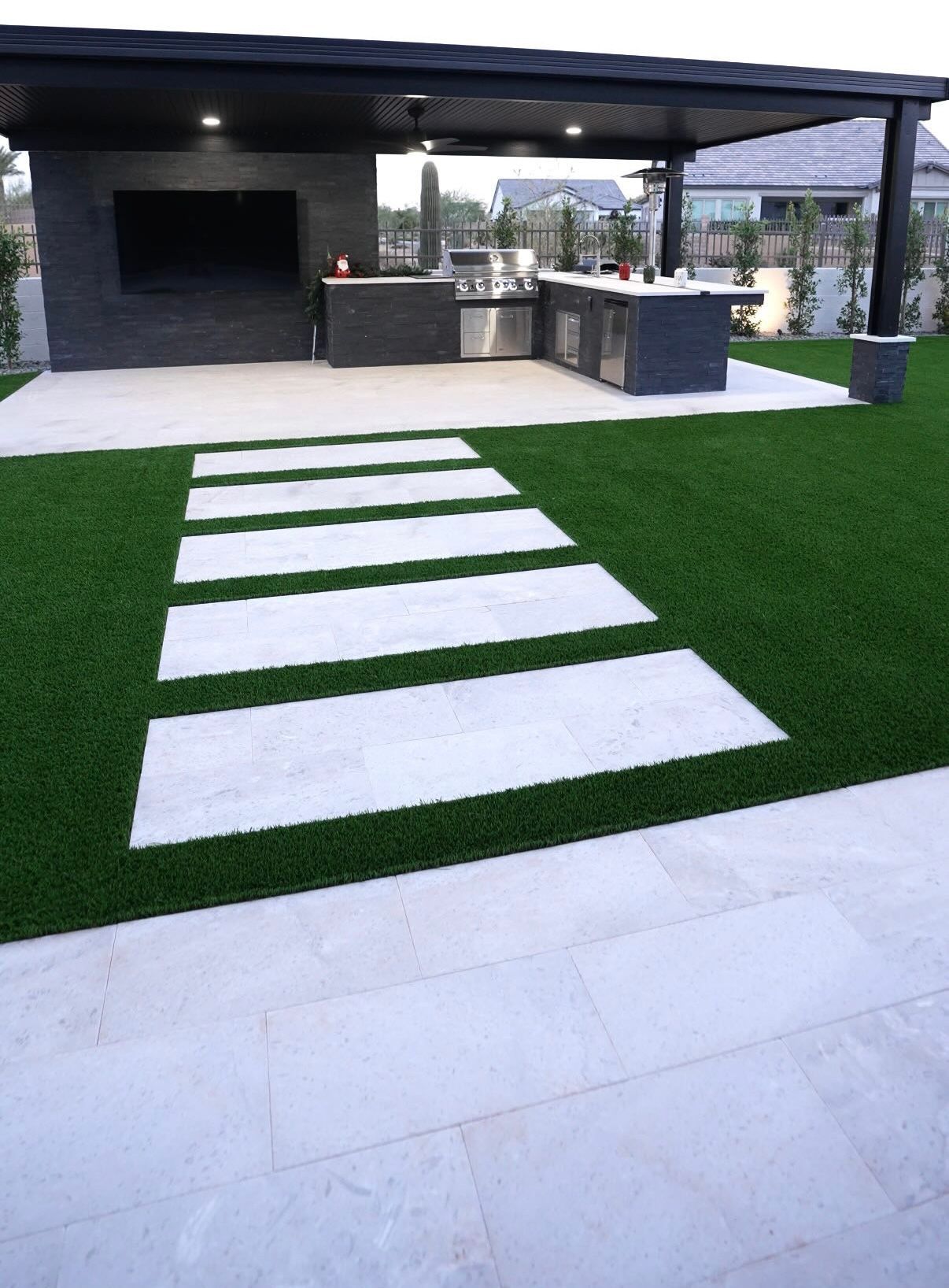 A patio with a kitchen and a walkway leading to it.