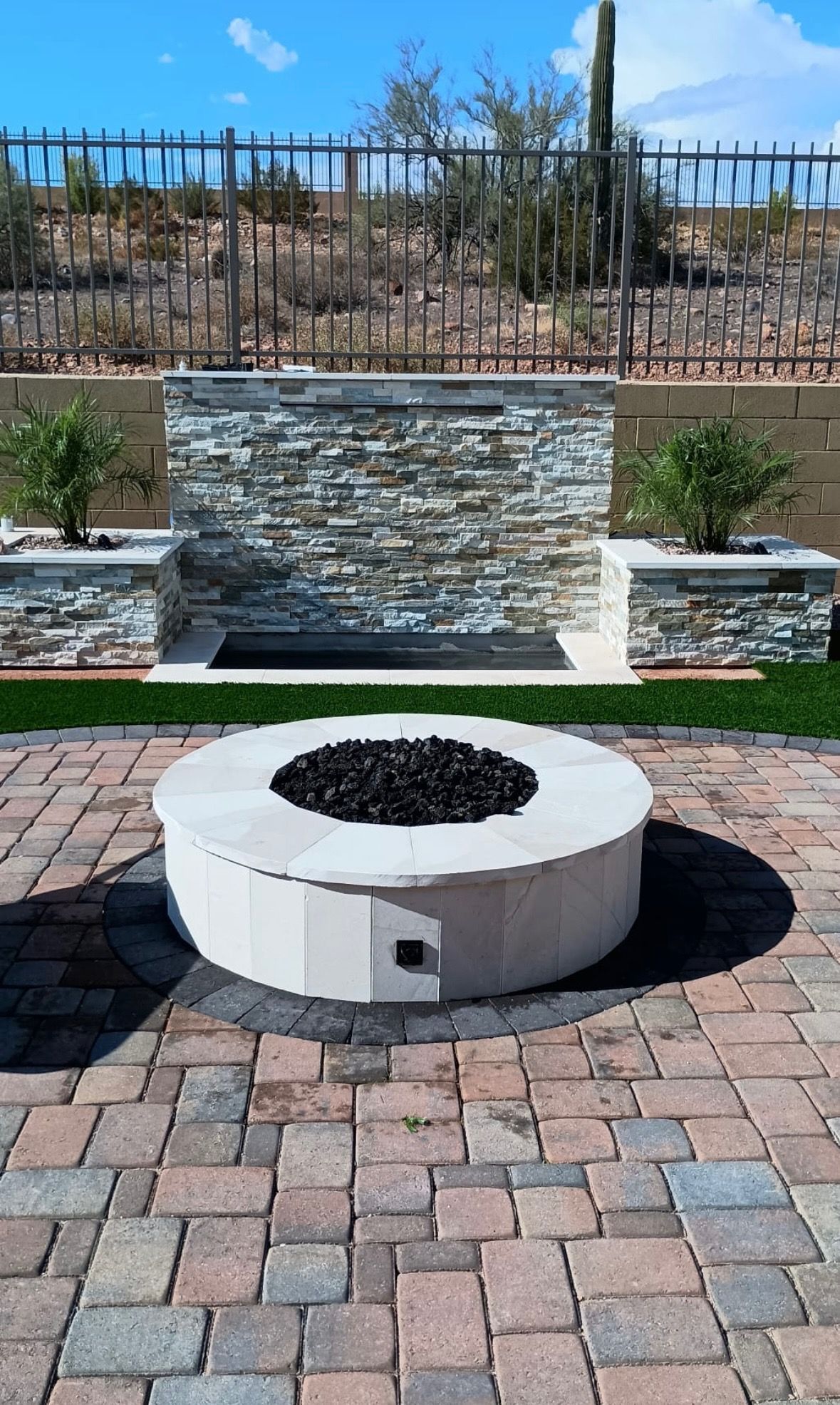 A fire pit is sitting on top of a brick patio.