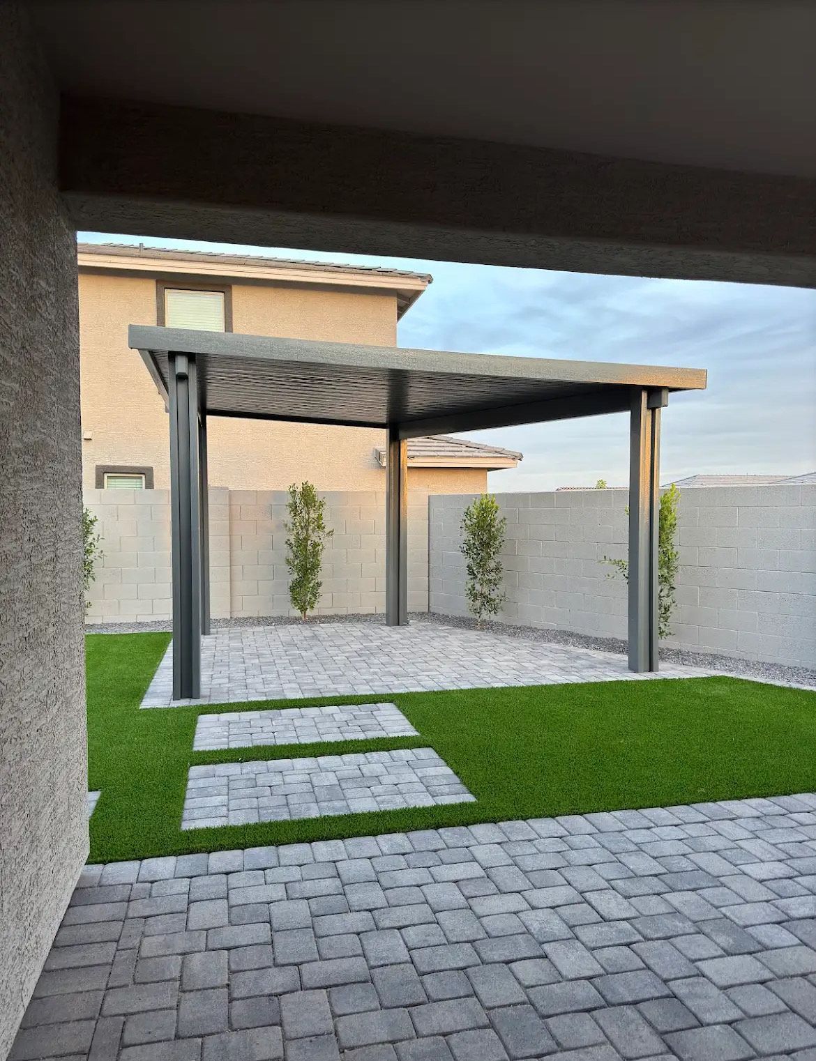 A patio with a pergola and steps leading to it