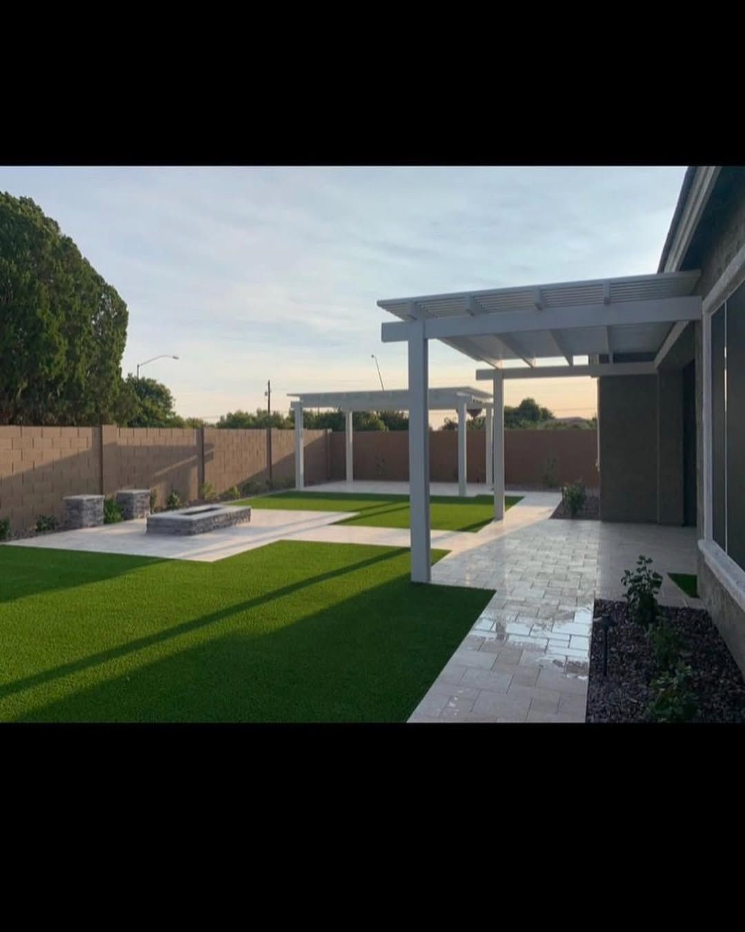 A backyard with a pergola and a fire pit