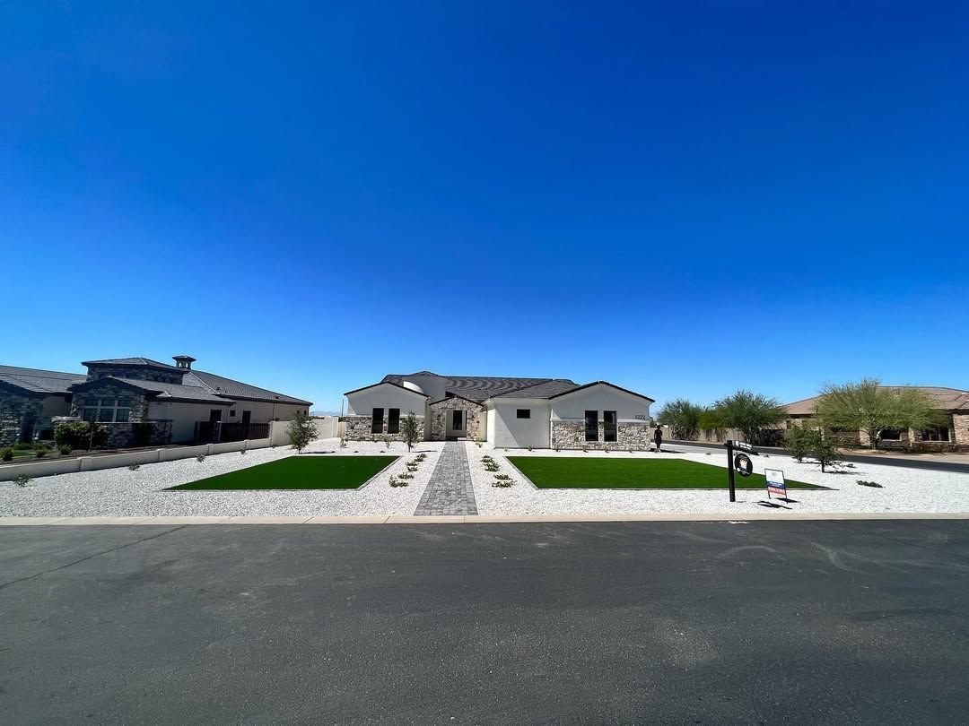 An aerial view of a house with a large lawn in front of it.
