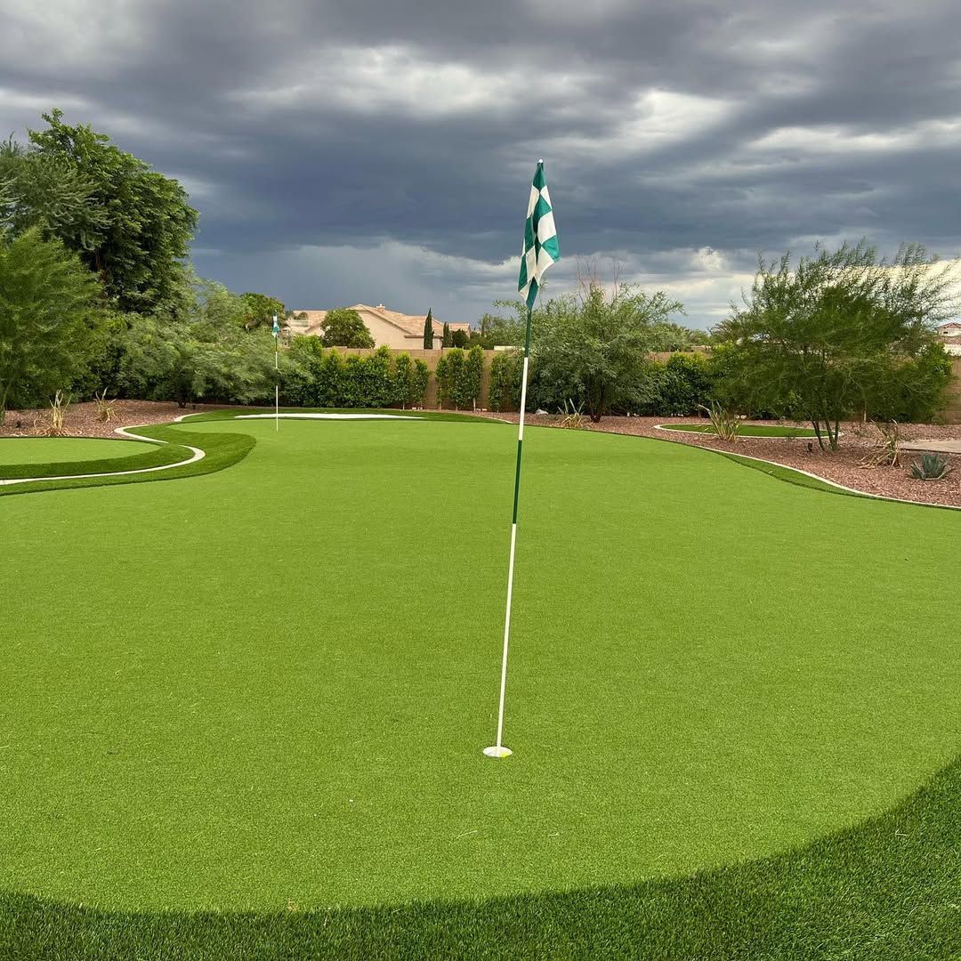 A green golf course with a flag on the green.