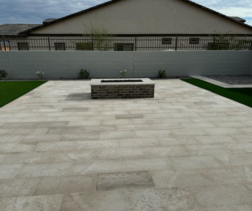 A patio with a fire pit in the middle of it
