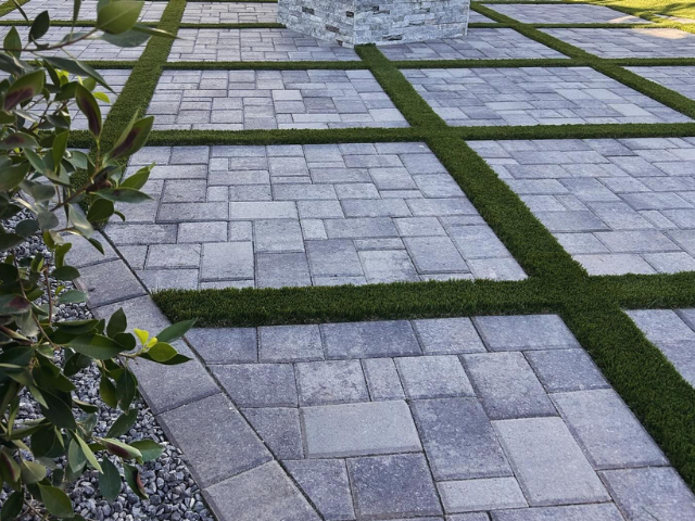 A brick walkway with grass between the bricks