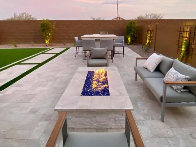 A patio with a table and chairs and a fire pit