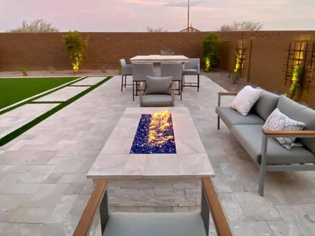 A patio with a table and chairs and a fire pit