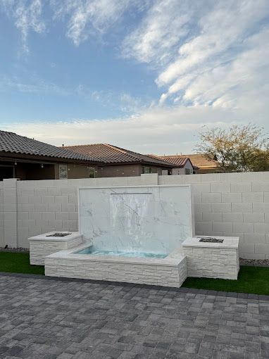 There is a waterfall in the backyard of a house.
