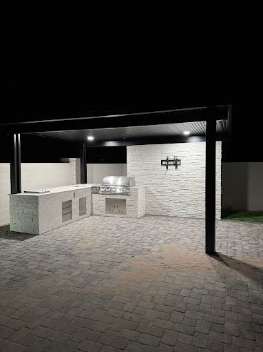 A large outdoor kitchen is lit up at night.
