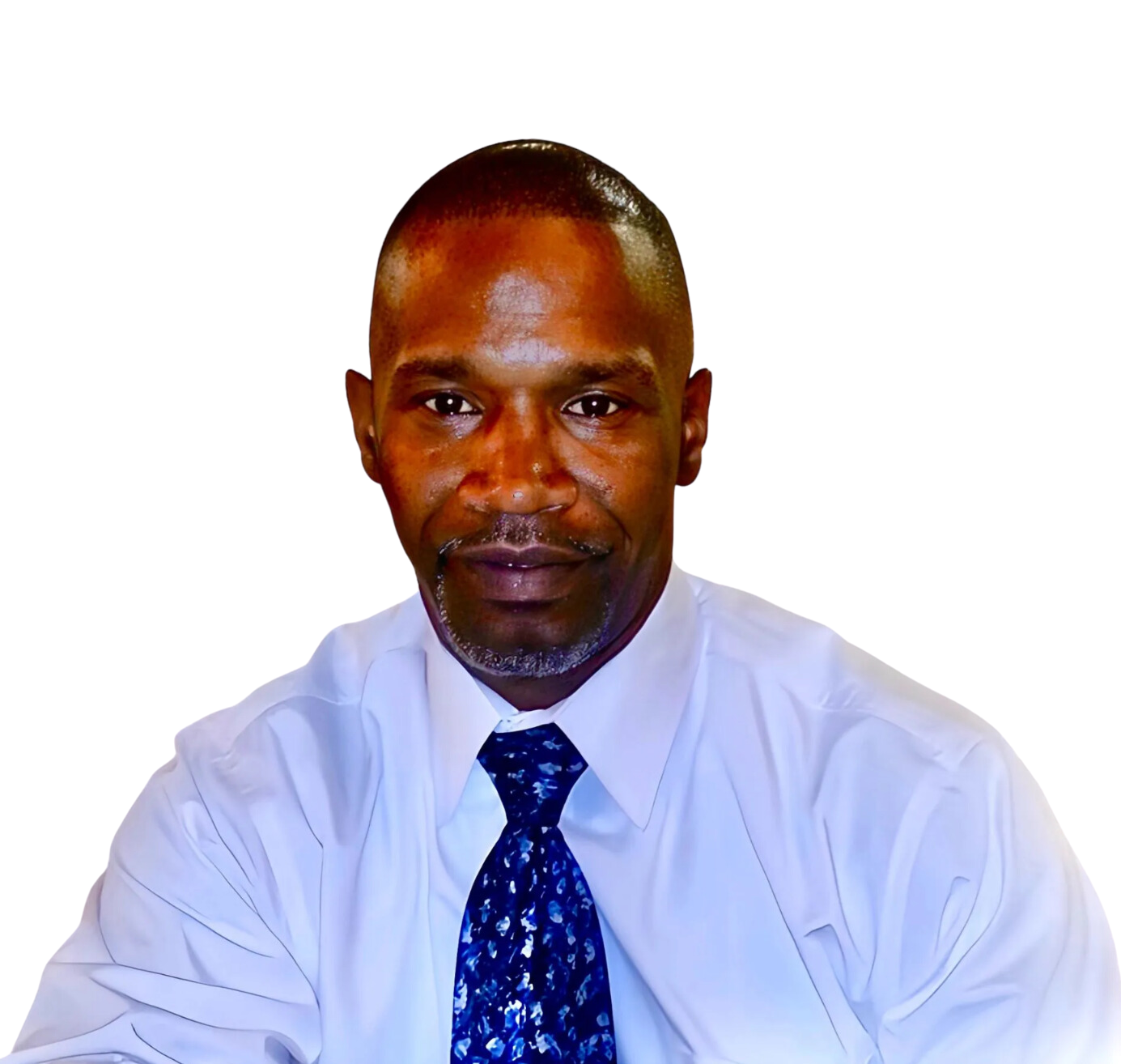 A man in a white shirt and blue tie looks at the camera