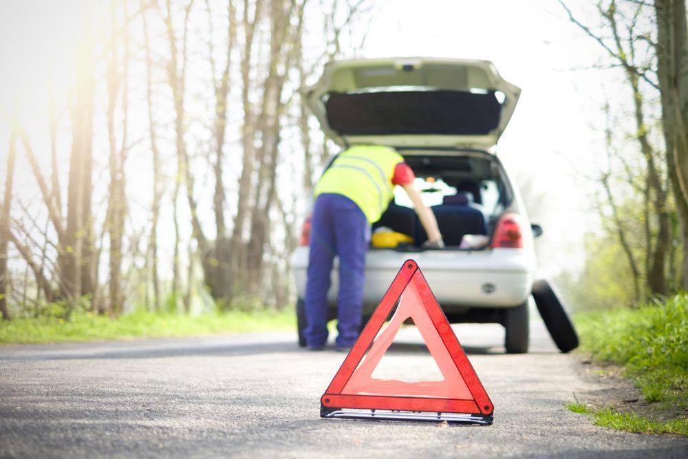 Man is Changing a Tire on a Broken Down Car — 365 Towing Taree in Oldbar, NSW