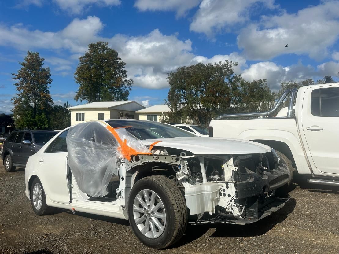 White Car is Wrapped in Plastic and Sitting in a Parking Lot — 365 Towing Taree in Newcastle, NSW