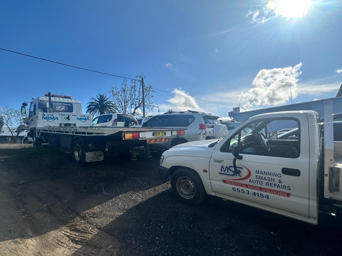 Tow Truck is Towing a Car in a Parking Lot — 365 Towing Taree in Wingham, NSW