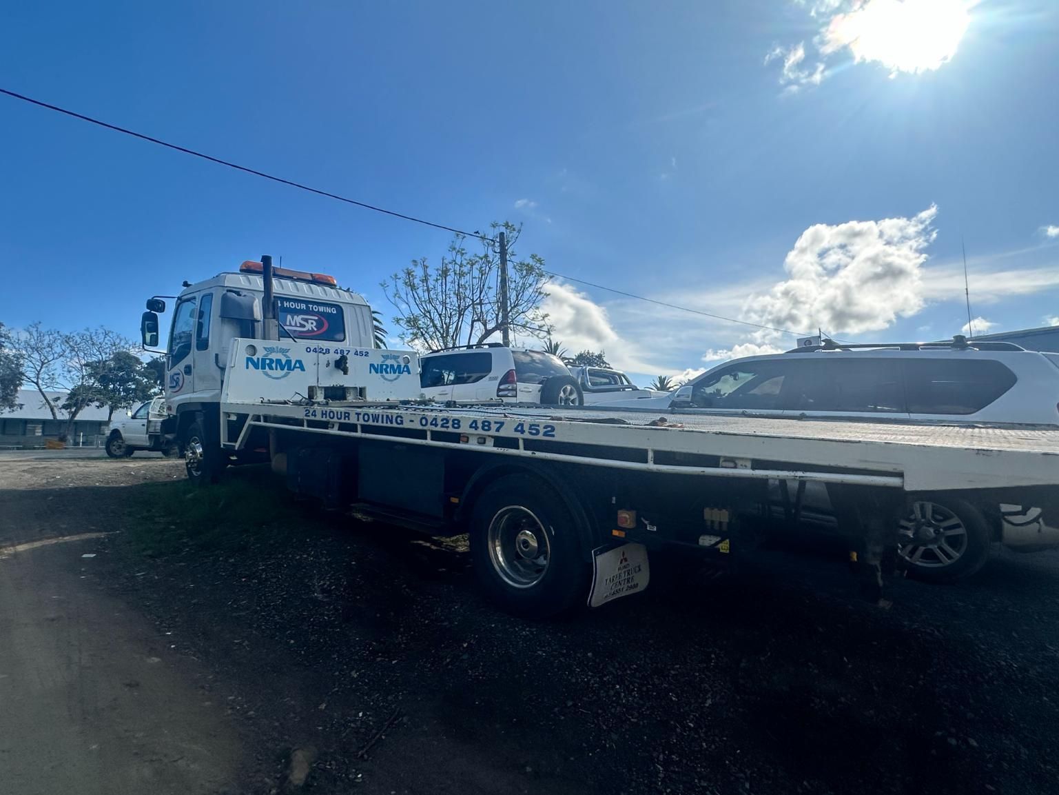 Tow Truck is Parked in a Parking Lot Next to a Car — 365 Towing Taree in Port Macquarie, NSW